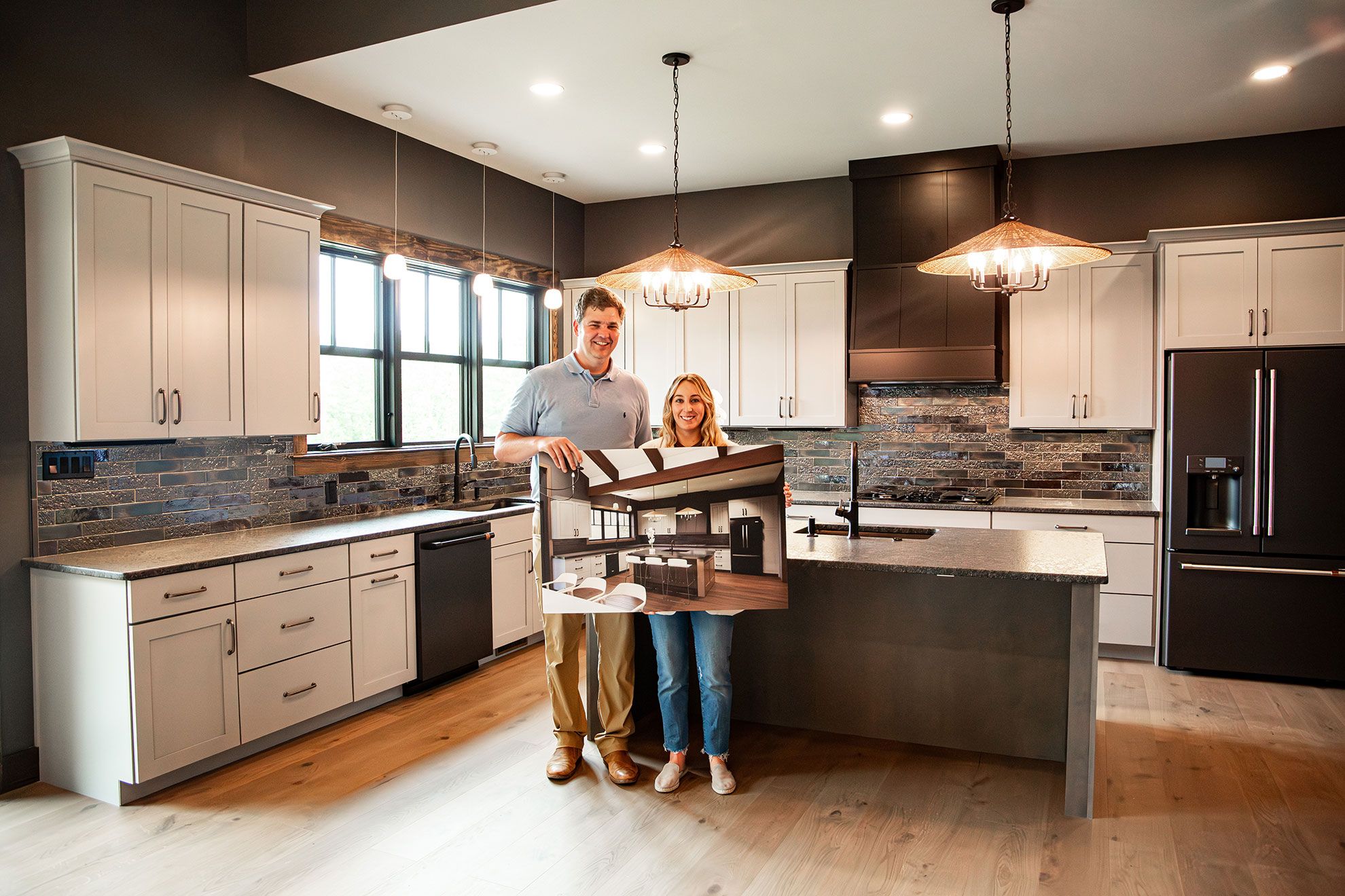 People holding rendering of kitchen in new kitchen