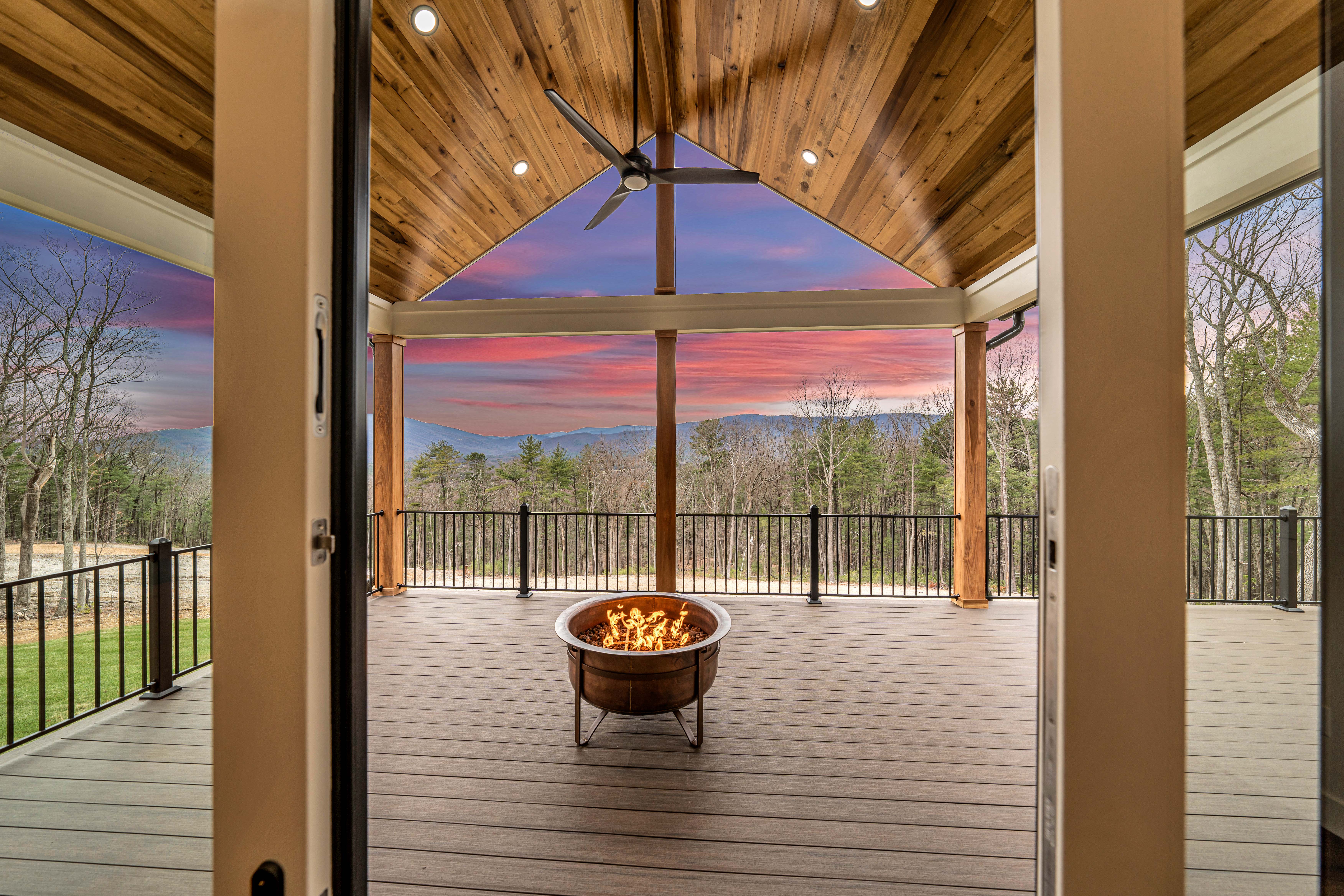 View of fire pit on covered back deck with wood ceiling